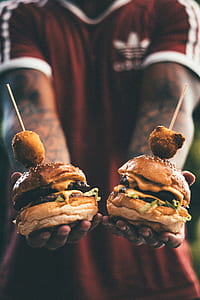 person holding two cheeseburgers thumbnail