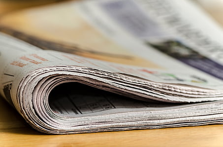 newspapers on brown wooden surface thumbnail