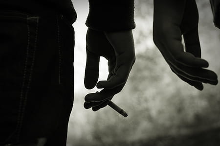 person holding cigarette grayscale photo thumbnail