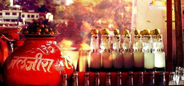 clear glass bottles beside red ceramic vase thumbnail