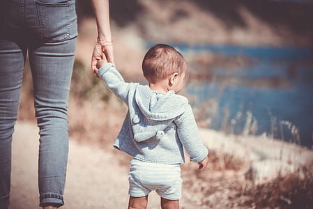 person holdin baby weaing blue sweater thumbnail