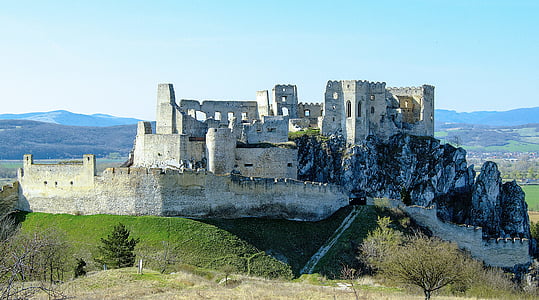 ruin gray concrete castle under white and blue skies thumbnail