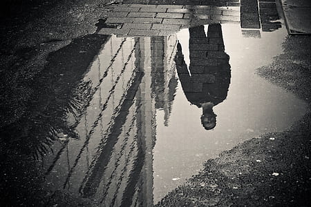 grayscale photo of man refletion on water thumbnail