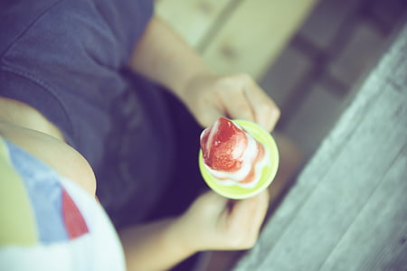person holding popsicle in tilt-shift lens photography thumbnail
