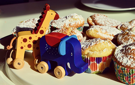 shallow focus photography of brown Giraffe and blue Elephant wooden toys on table thumbnail