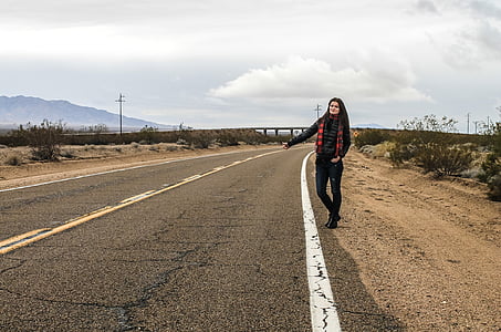 woman standing on roadway during daytime thumbnail