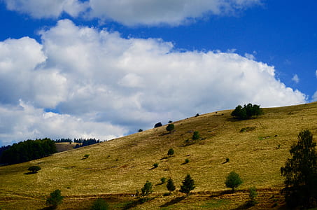 landscape photograph of green mountains under cumulus clouds thumbnail