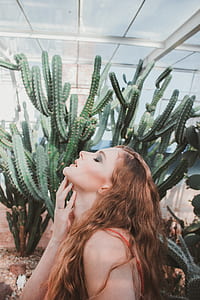 woman holding her neck near cactus plant thumbnail