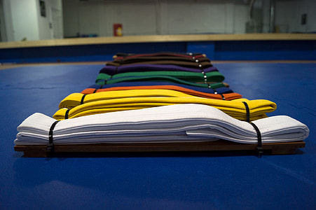 assorted-color karate belt on blue surface inside room thumbnail