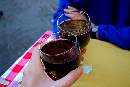 person holding clear wine glass filled with red wine thumbnail