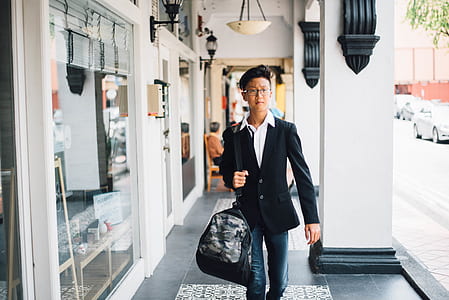 man walking with black crossbody bag at daytime thumbnail