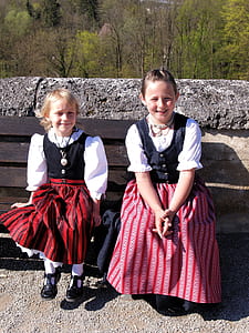 two girl's sitting on brown wooden bench at daytime thumbnail