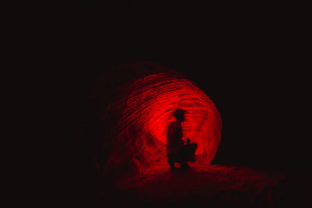silhouette of person sitting near red light thumbnail