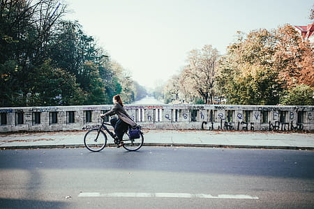 A young caucasian female cyclist on a river bridge in a winter day thumbnail