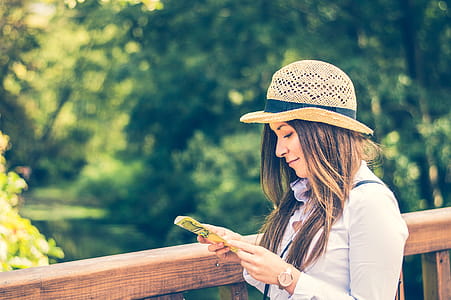 Woman Holding Printing Paper Near Trees thumbnail