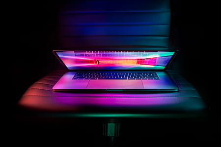 silver and black laptop computer on leather chair thumbnail