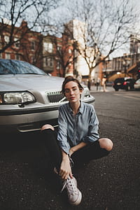 woman seating behind silver car during daytime thumbnail