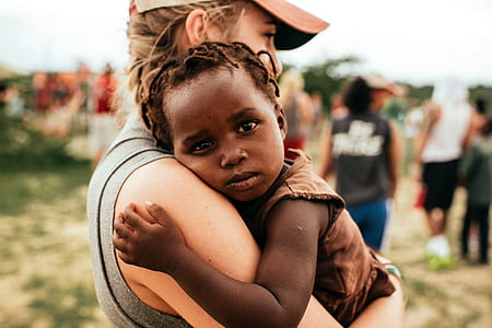 woman carrying child during daytime thumbnail