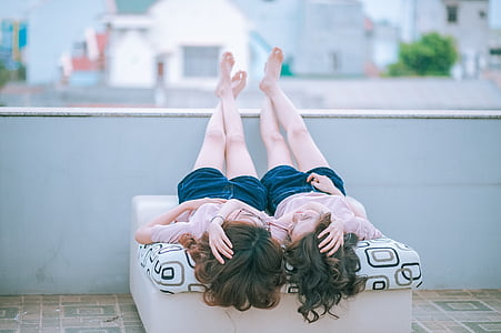 two women lying on bed thumbnail