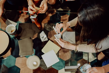 Women folding sheet of paper while making origami thumbnail
