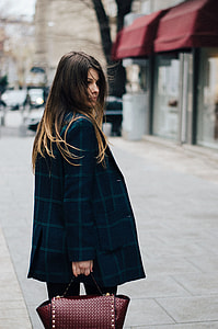 woman in blue check coat holding brown leather handbag during daytime thumbnail
