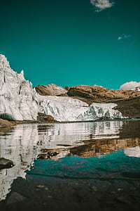 gray and brown rock formations near body of water at daytime thumbnail
