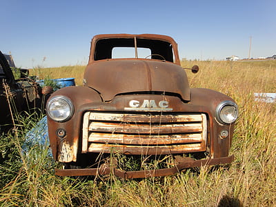 rusted GMC truck on field during daytime thumbnail