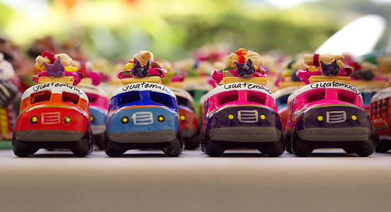 selective focus photo of four assorted-colored vehicle toys thumbnail