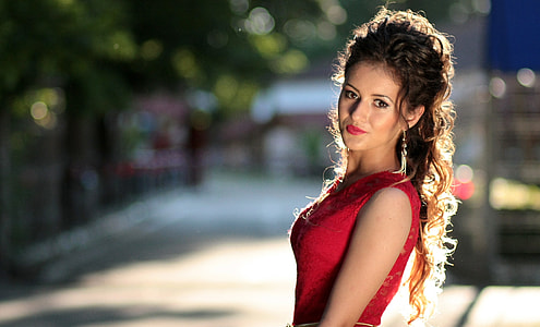 selective focus photography of woman wearing red sleeveless dress thumbnail