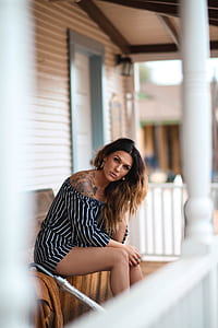 woman wearing rompers sitting on chair thumbnail
