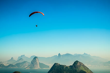 person paraglides near mountain thumbnail