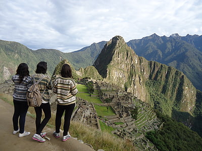 three women standing while looking at mountain range thumbnail