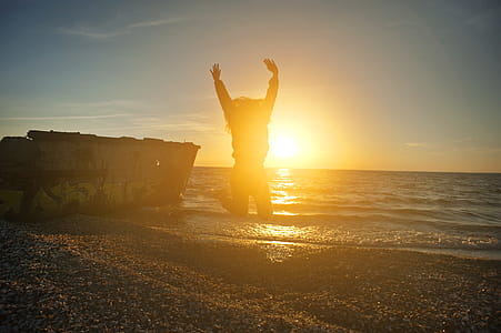Person Jumping on Seashore during Golden Hour thumbnail