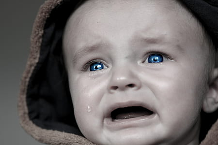 grayscale photo of baby crying wearing brown hoodie thumbnail