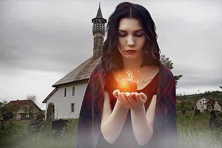 woman wearing red top and holding apple with fire during daytime thumbnail