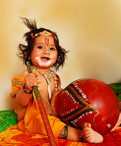baby holding red and brown staff thumbnail