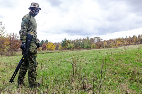 Photo of Man Wearing Green Combat Uniform Holding Rifle thumbnail