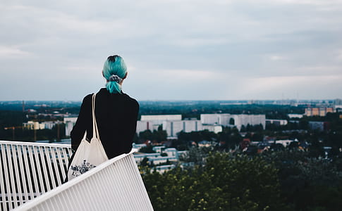 woman carrying white bag standing near railing thumbnail