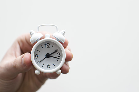 person holding mini double bell alarm clock at 2:17 thumbnail