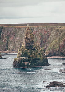 rock formation between body of water thumbnail