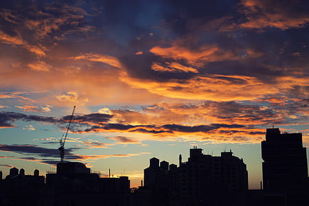 silhouette of city under orange sky thumbnail