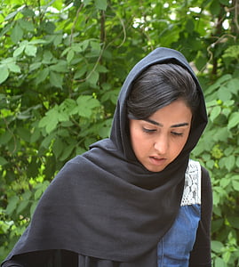 woman wearing black hijab looking down near green plants thumbnail