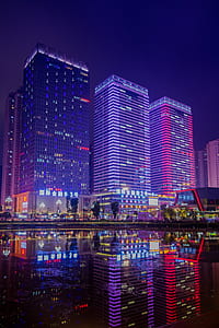 reflection photography of three high-rise buildings on body of water thumbnail