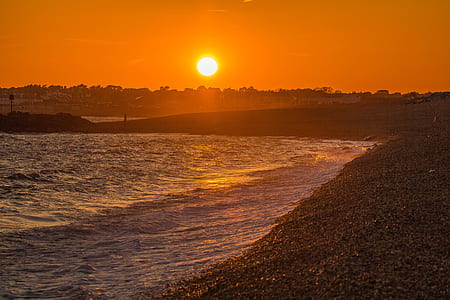 photo of seashore under golden sky thumbnail