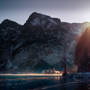 snow covered mountain near body of water during daytime thumbnail