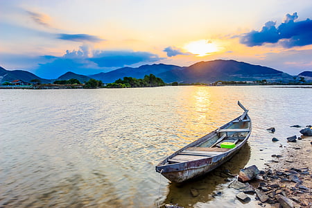 gray boat placed on seashore during daytime thumbnail