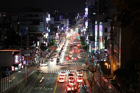 aerial photography of city intersection with buildings and heavy traffic at night thumbnail