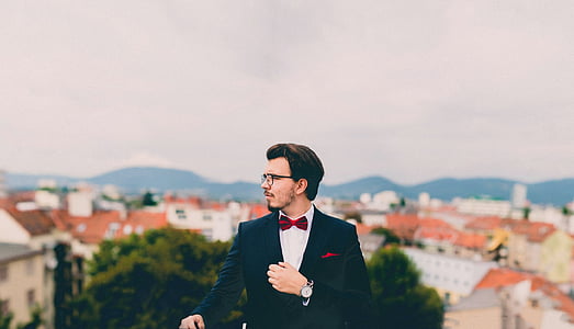 man in black suit taking photo outside thumbnail