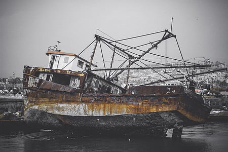 brown and white wreck boat during daytime thumbnail