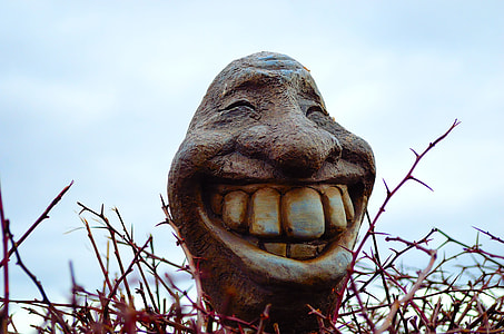 statue of smiling man's face under cloudy sky during daytime thumbnail